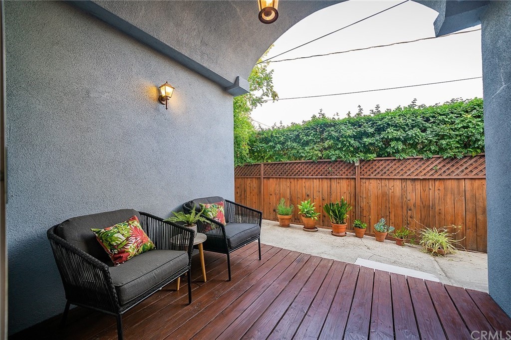 A cozy patio area with comfortable seating and a view of a small garden.