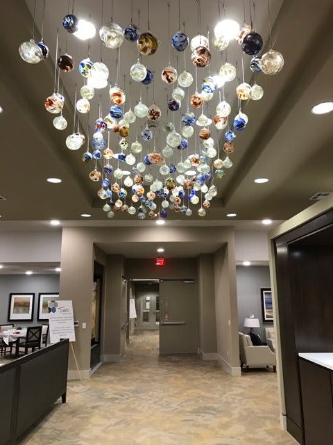 A modern lobby with a decorative chandelier hanging from the ceiling.
