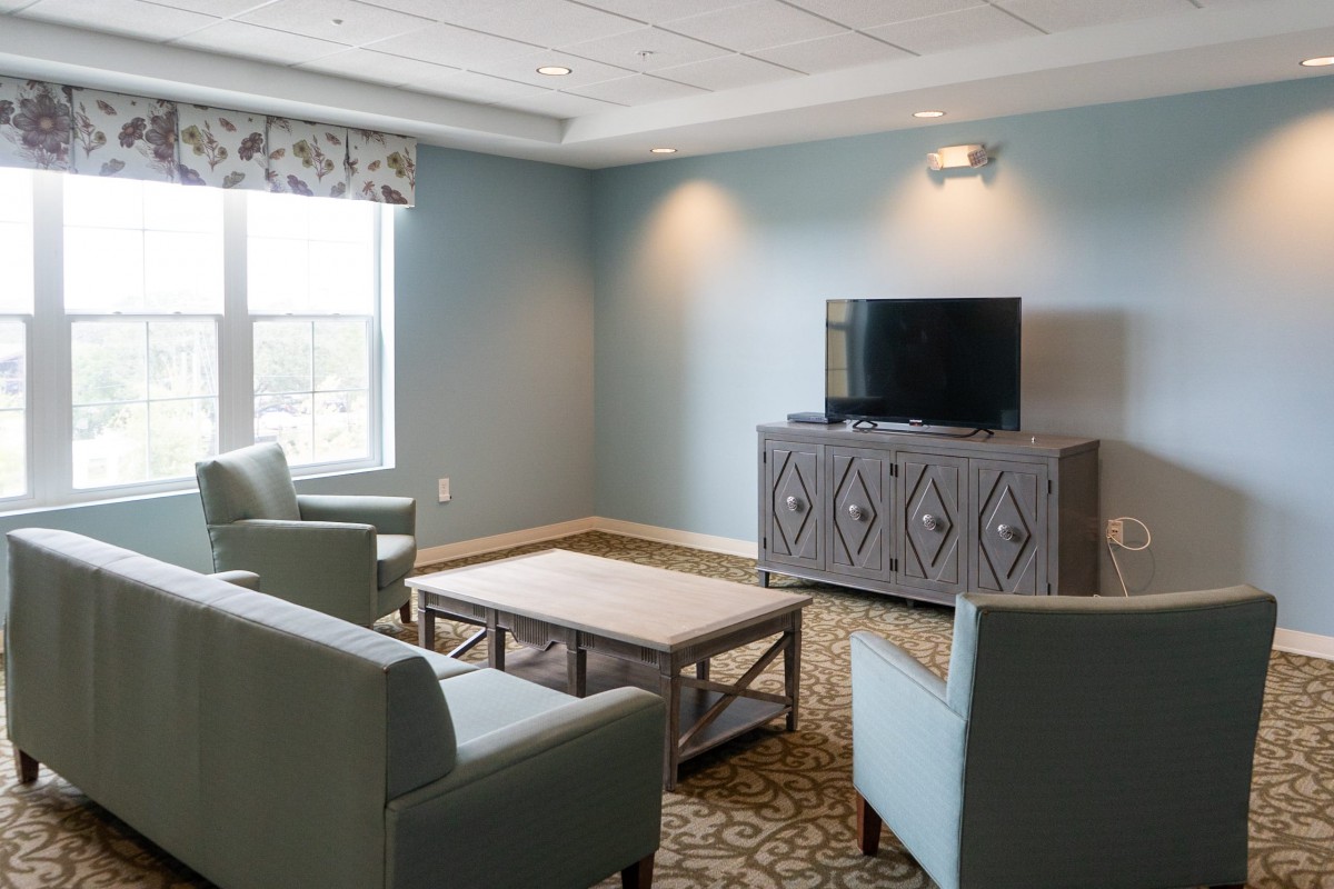A cozy living room with a television, sofas, and a coffee table.