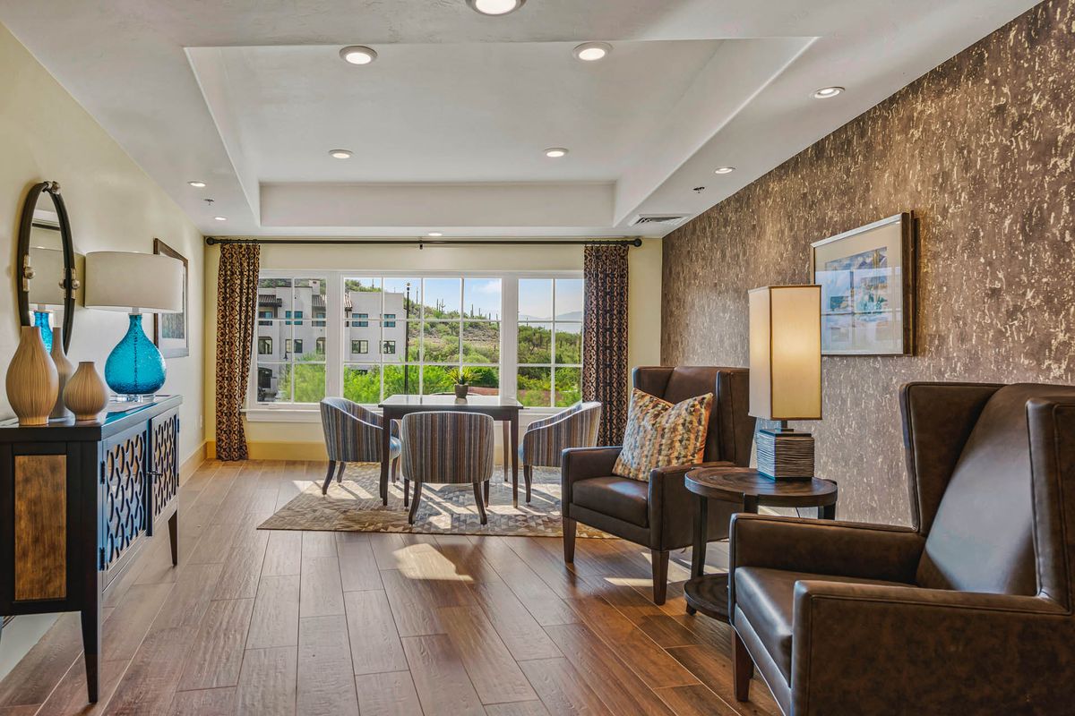 A cozy and well-lit living room with modern furniture and large windows.