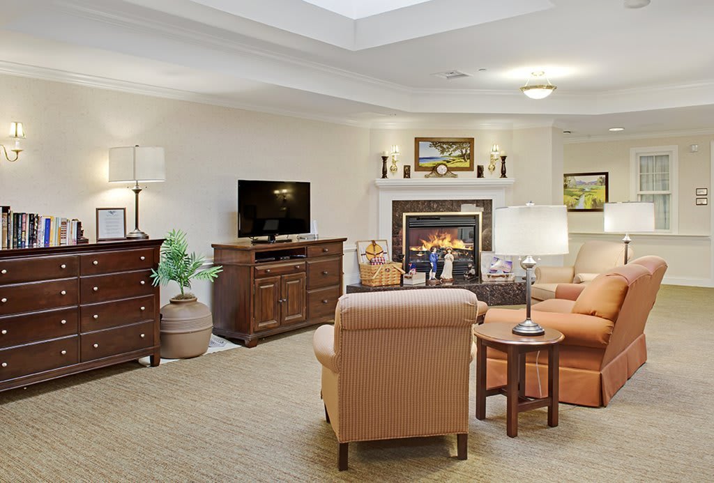 A cozy living room with a fireplace, comfortable seating, and a television.