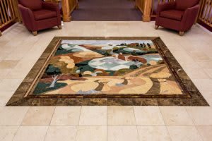An abstract art rug displayed on a tiled floor in an interior setting.