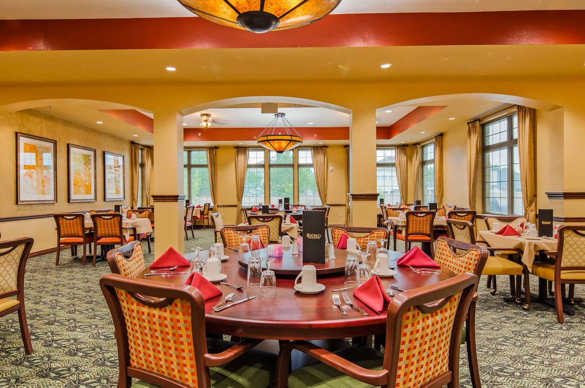 An elegant dining room with neatly set tables and comfortable chairs.