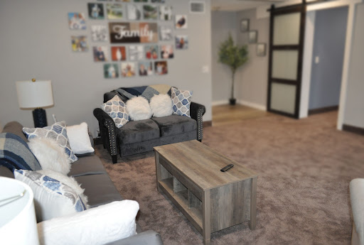 A cozy living room featuring a stylish sofa, a wooden coffee table, and decorative wall art.