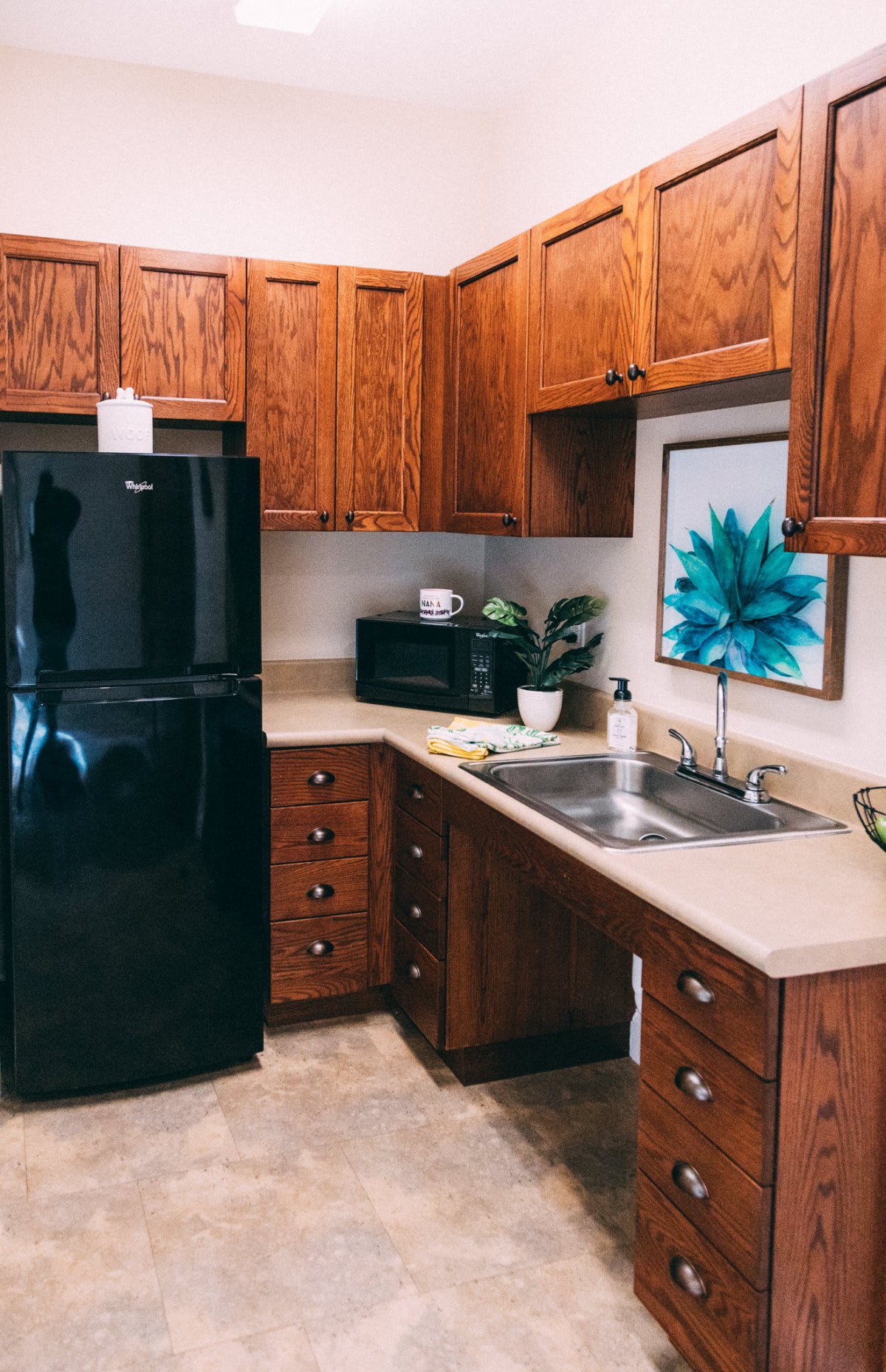 A cozy kitchen with wooden cabinets, a black refrigerator, and modern appliances.