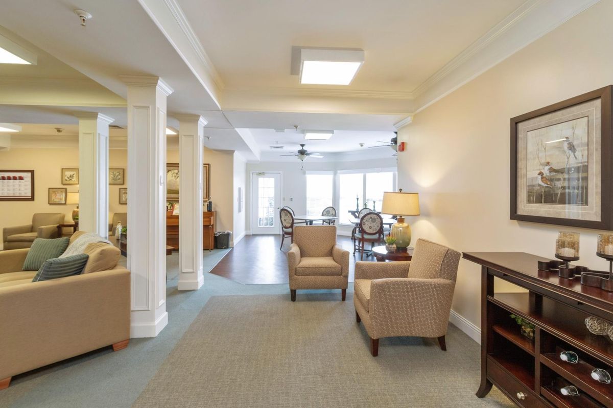 A cozy living room area with armchairs and a coffee table, featuring soft lighting and elegant decor.