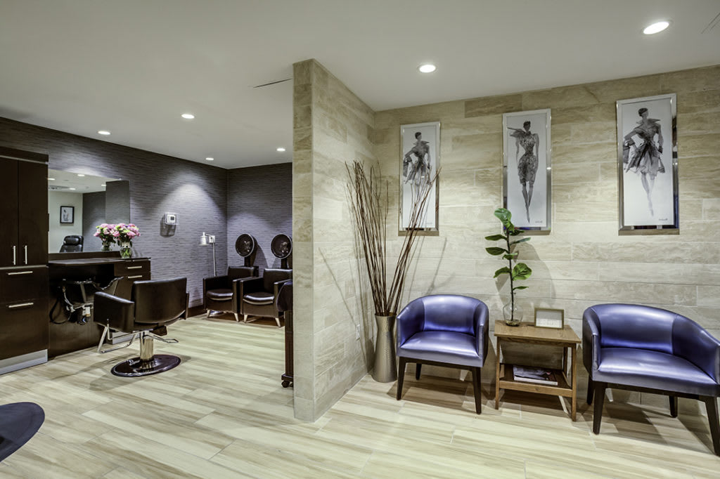 A modern salon waiting area with stylish seating and artwork on the walls.