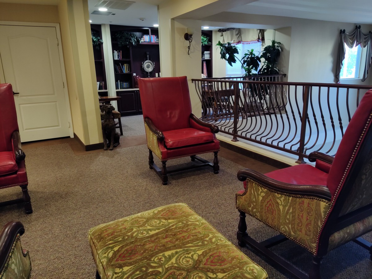 A cozy lobby area with elegant chairs and a bookshelf.
