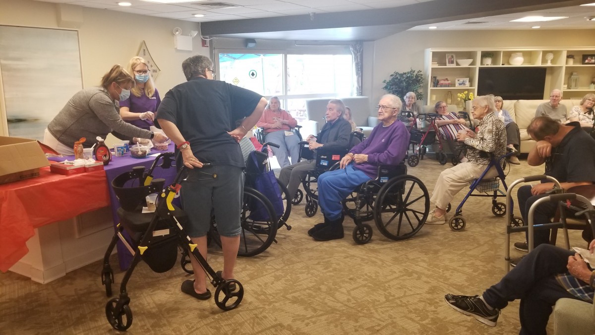 A group of elderly individuals in wheelchairs gathered together in a nursing home setting.