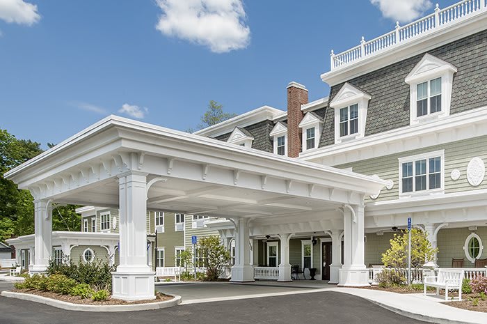 A grand entrance with white columns and a covered driveway.