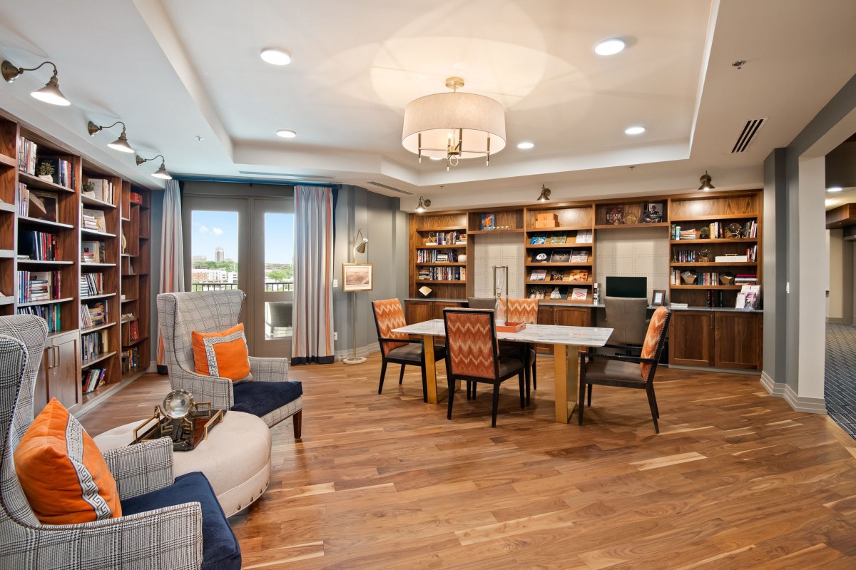A modern living room featuring a spacious seating area, wooden floors, and built-in bookshelves.