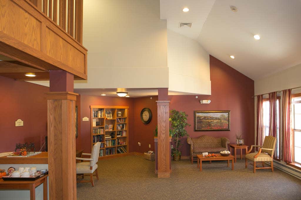 A cozy lobby interior with a seating area, bookshelf, and decorative elements.
