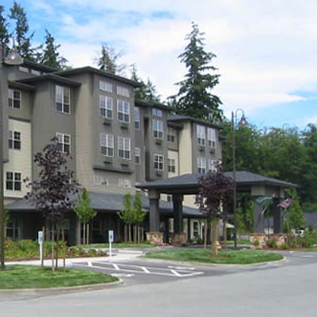 A multi-story hotel or residential building surrounded by trees.