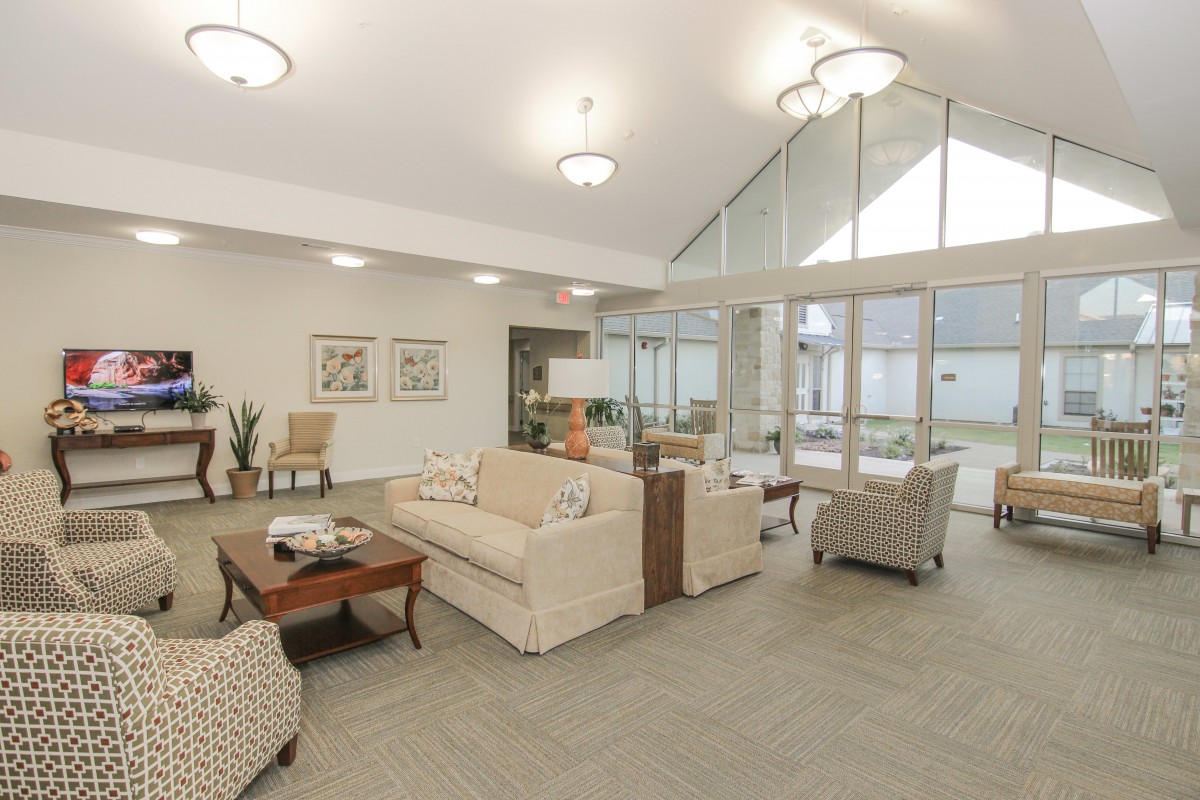 A spacious and bright living room with modern furniture and large windows.