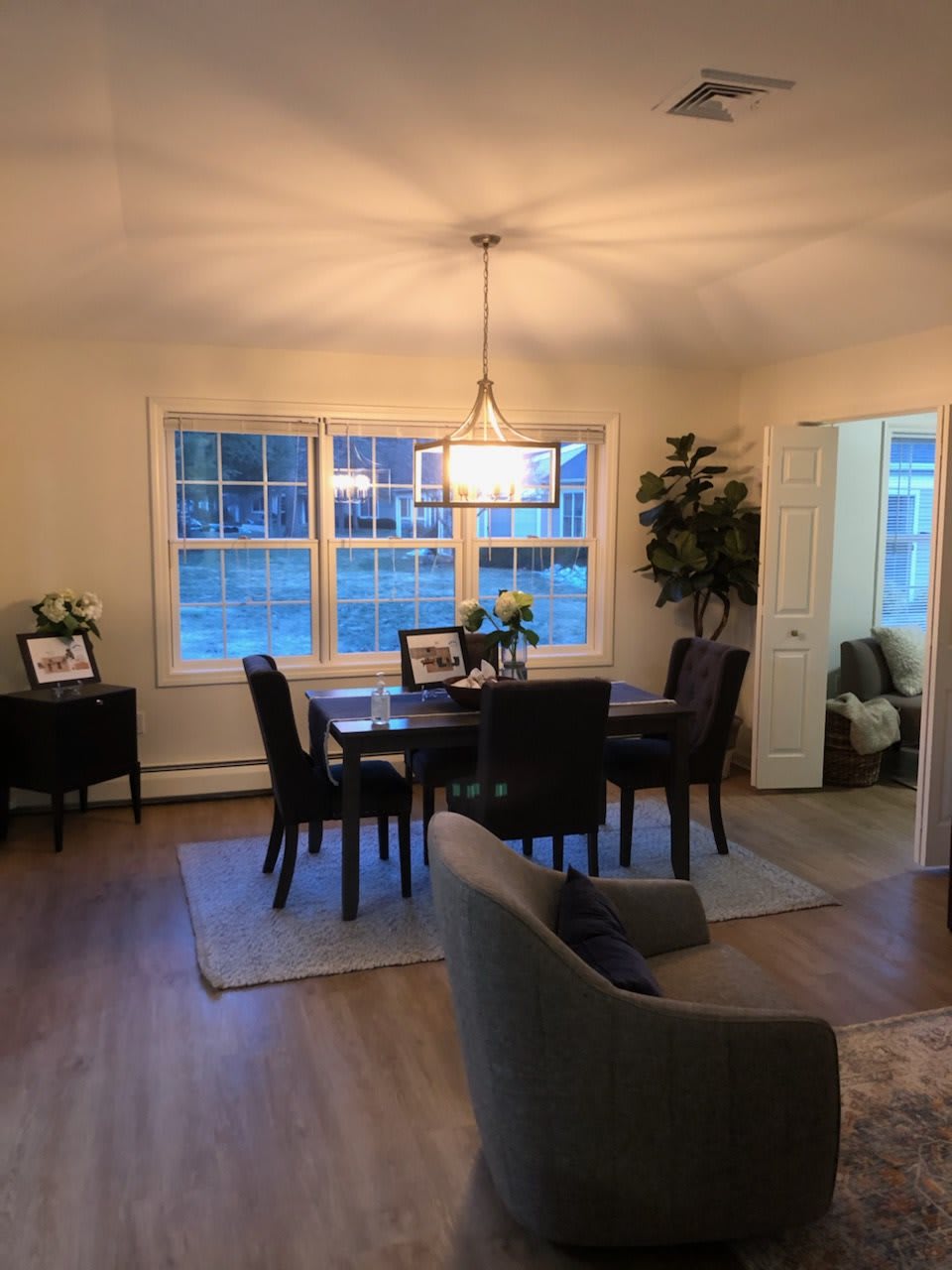 A cozy dining room with a modern light fixture and elegant decor.