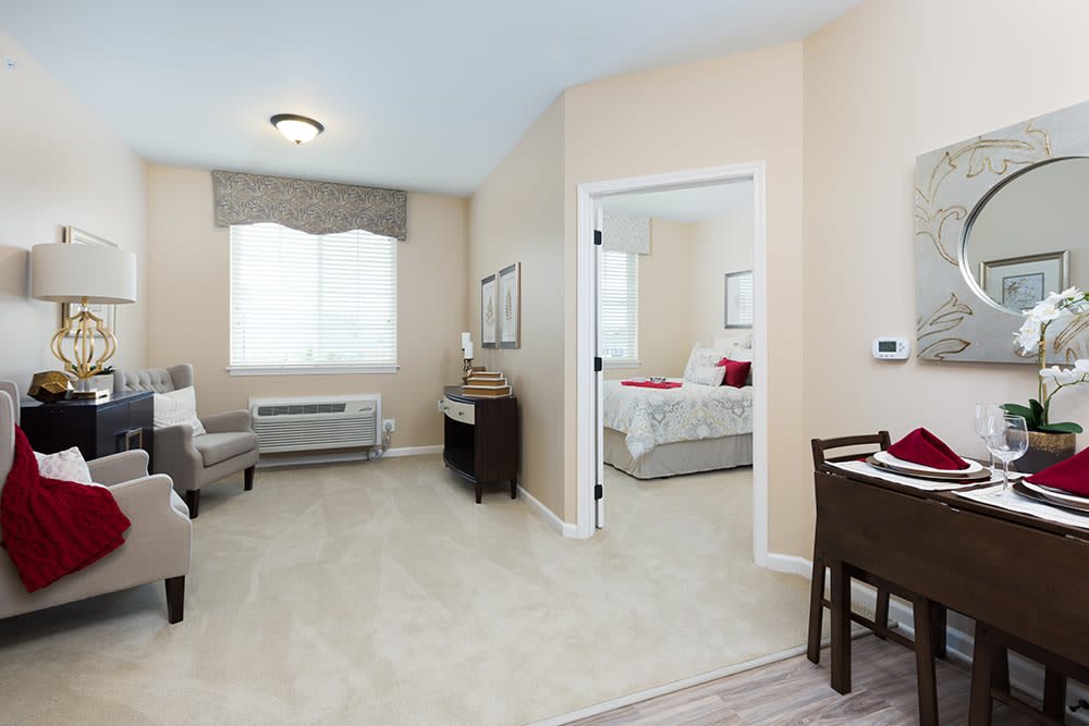 A modern apartment interior featuring a connected living room and bedroom with elegant furniture and decor.