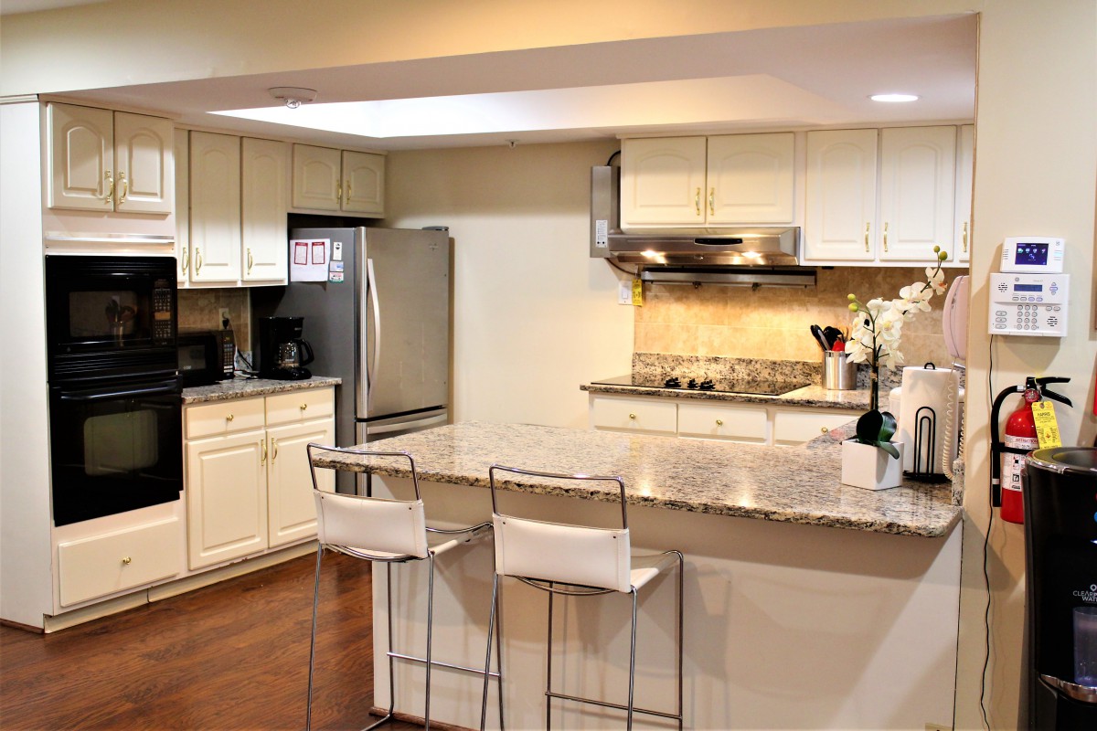 Modern kitchen with stainless steel appliances and a breakfast bar.