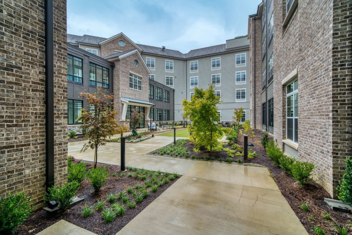 A modern courtyard with a landscaped garden in an urban residential building complex.