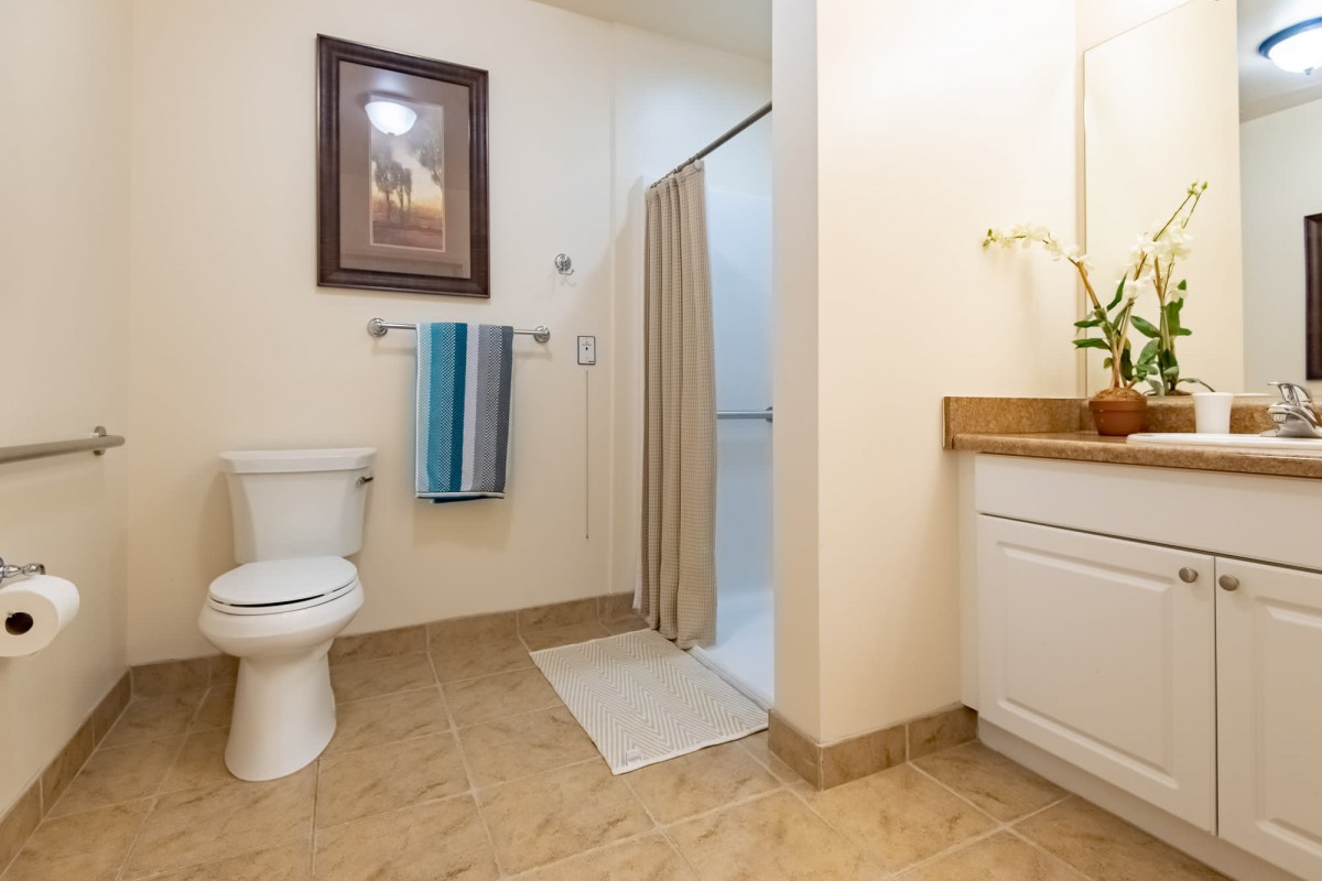 A clean and well-organized bathroom with a toilet, shower, and sink.