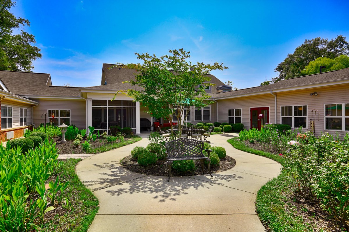 A well-maintained residential building with landscaped gardens and a central pathway.