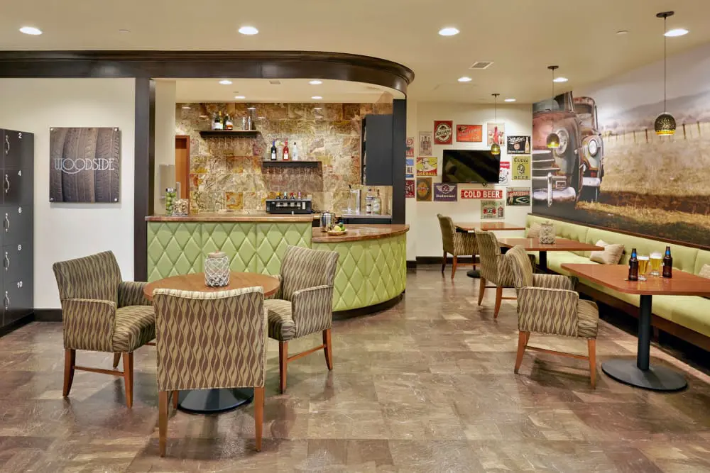 A cozy restaurant interior featuring a seating area with tables and chairs, bar section, and decorative elements.