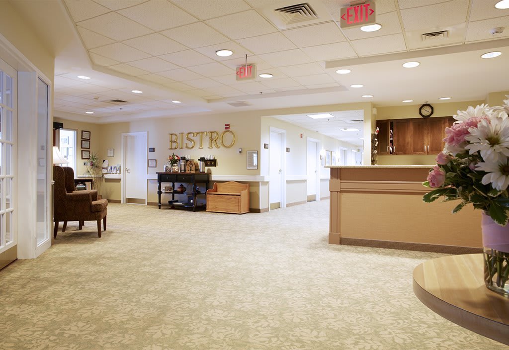 A spacious hospital lobby with a reception desk and a bistro area.