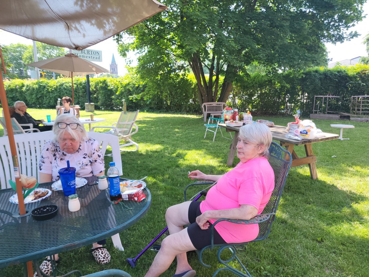 People relaxing in a garden setting on a sunny day.