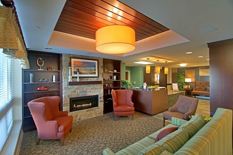 A modern and cozy living room with a fireplace, comfortable seating, and ambient lighting.