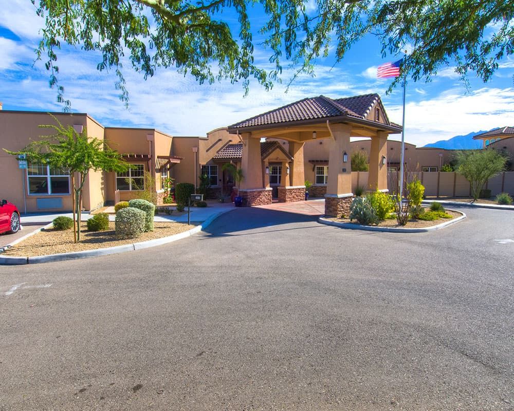 A sunny day view of a building entrance surrounded by desert landscaping.