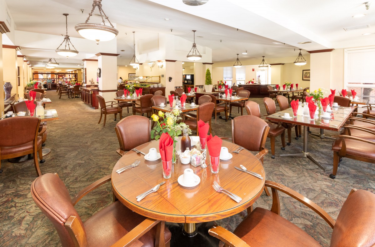A well-decorated dining area with set tables and chairs, prepared for guests.