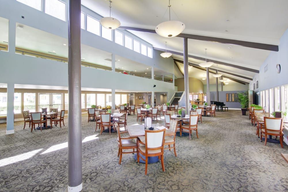 A spacious dining area with neatly arranged tables and chairs under ample lighting.