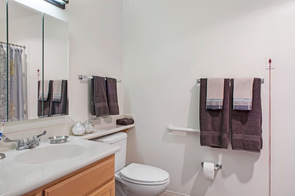 A clean and minimalist bathroom with neatly arranged towels and a modern sink.