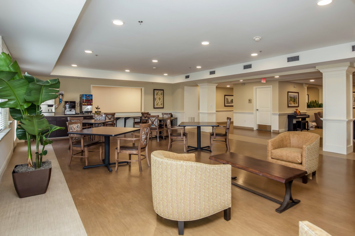 A cozy seating area with tables and chairs, featuring soft indoor lighting.