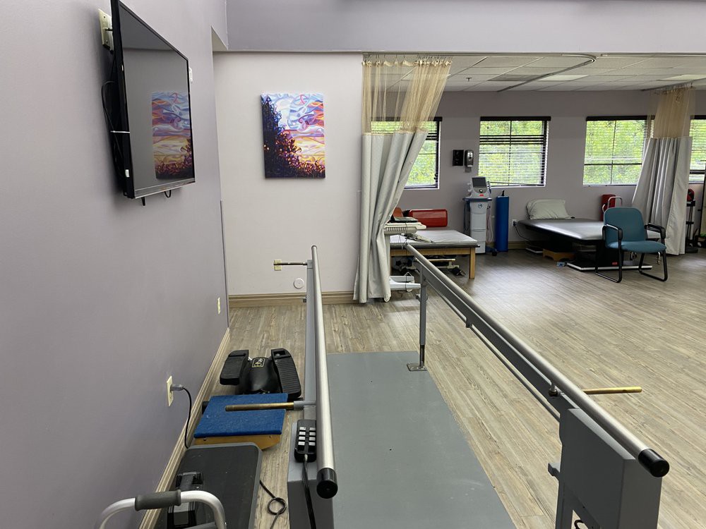 A physical therapy room equipped with parallel bars and exercise equipment.