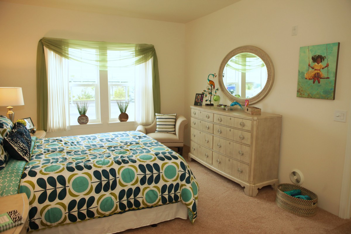 A cozy bedroom with colorful bedding and stylish furniture.