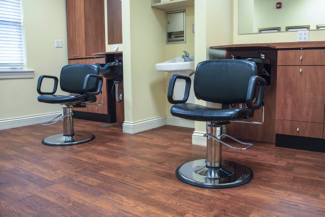 An interior view of a barbershop with styling chairs and mirrors.