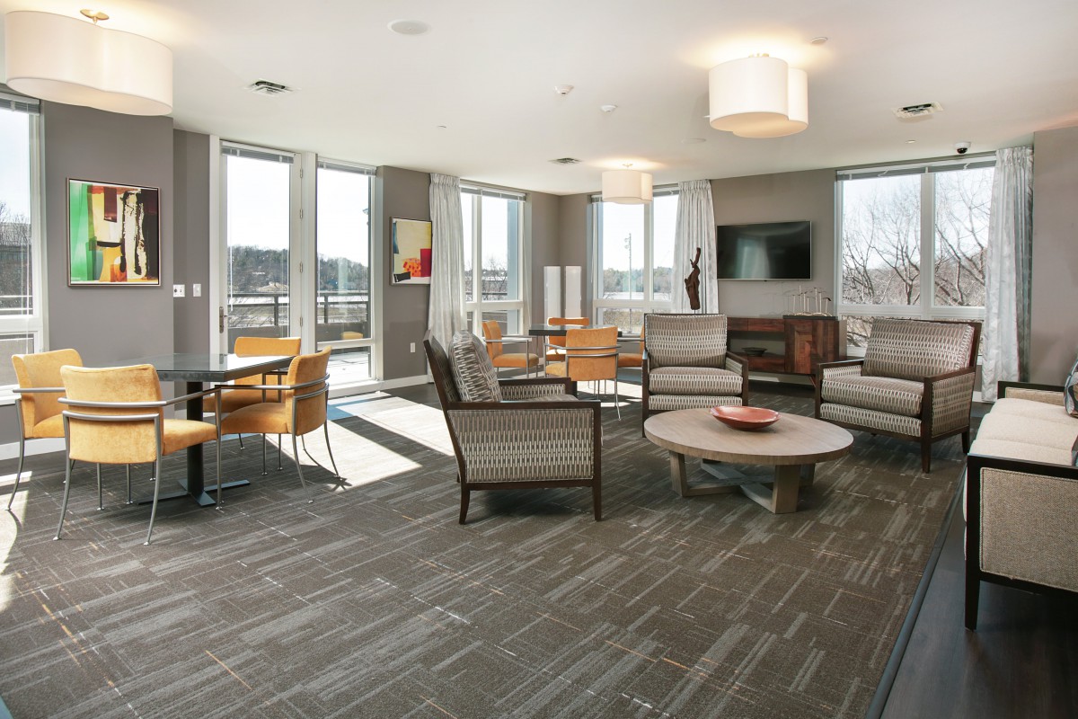 A modern and spacious living room with ample seating and large windows.