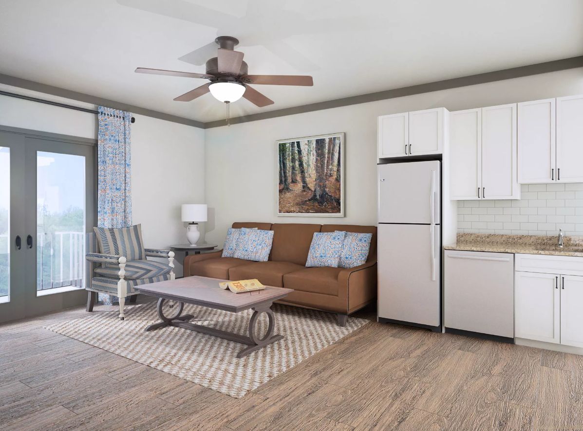 A modern living room with a cozy sofa, coffee table, and kitchenette.