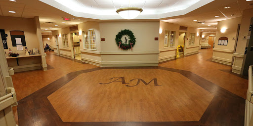 A welcoming lobby area decorated for the holiday season, featuring wooden flooring and a festive wreath.
