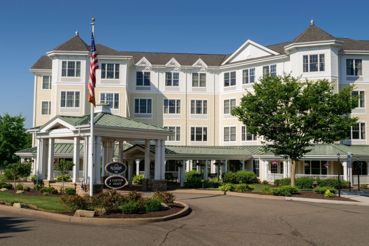 A view of a hotel exterior with neatly landscaped surroundings and a flagpole.