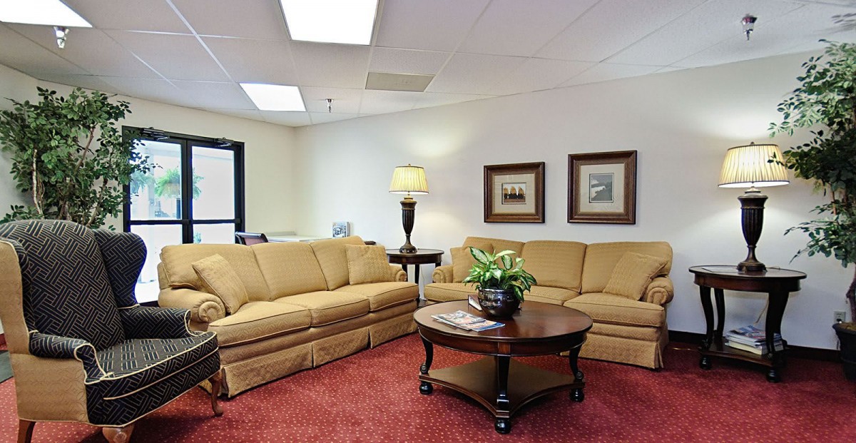 A cozy living room with beige sofas, a wooden coffee table, and decorative elements.