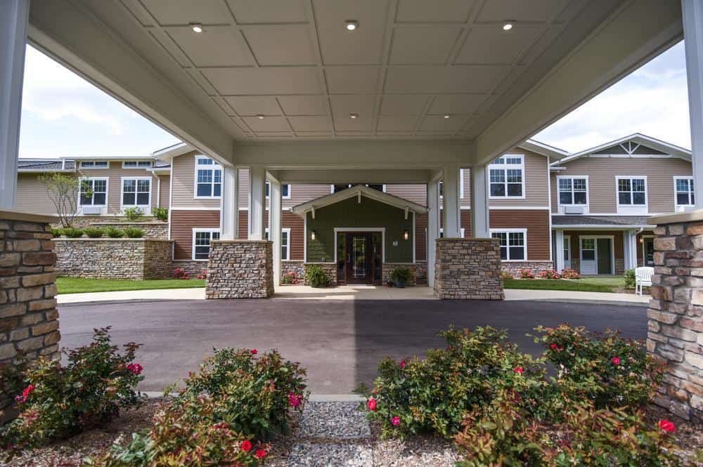 The entrance to a modern residential building with well-maintained landscaping.