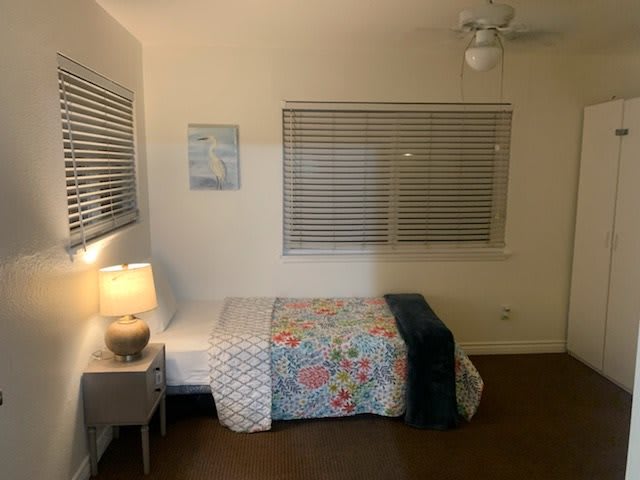 A cozy bedroom with a single bed, minimalist decor, and soft lighting.