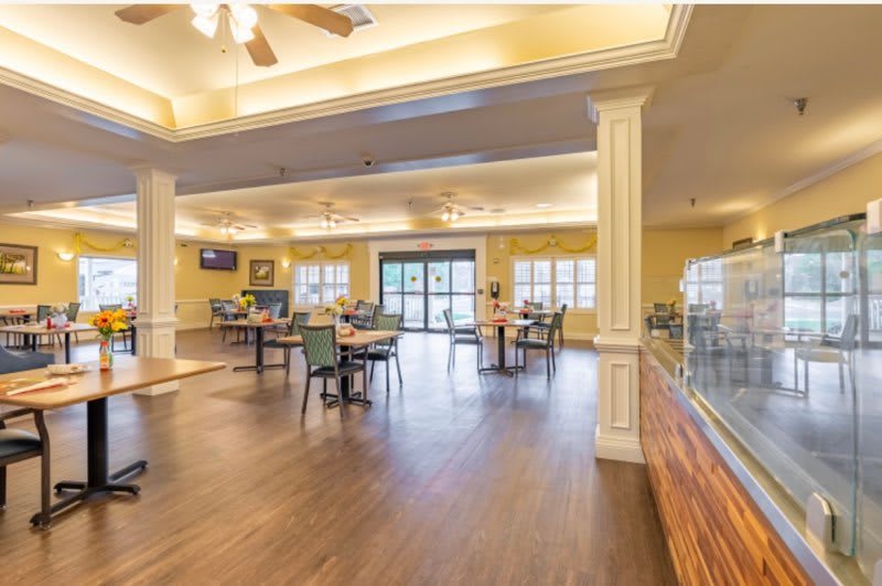 Spacious dining area with wooden flooring and bright lighting.