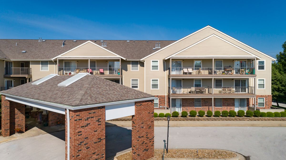 A residential apartment building with balconies and a covered entrance.