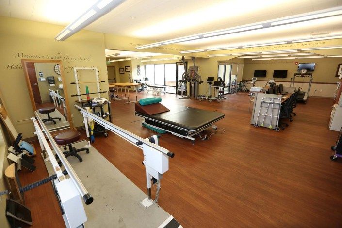 A spacious rehabilitation center equipped with physical therapy and exercise equipment.