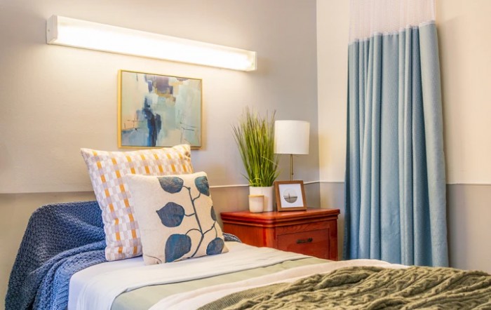 A cozy bedroom with decorative pillows and a stylish nightstand.
