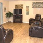 A cozy living room featuring leather recliners, a television, and tasteful wall art.