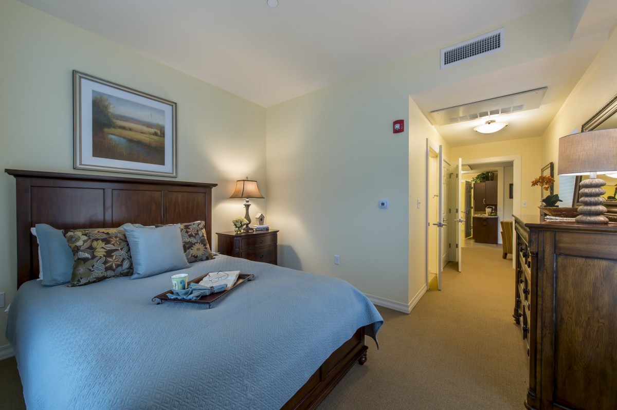 A cozy bedroom interior with a neatly made bed and soft lighting.