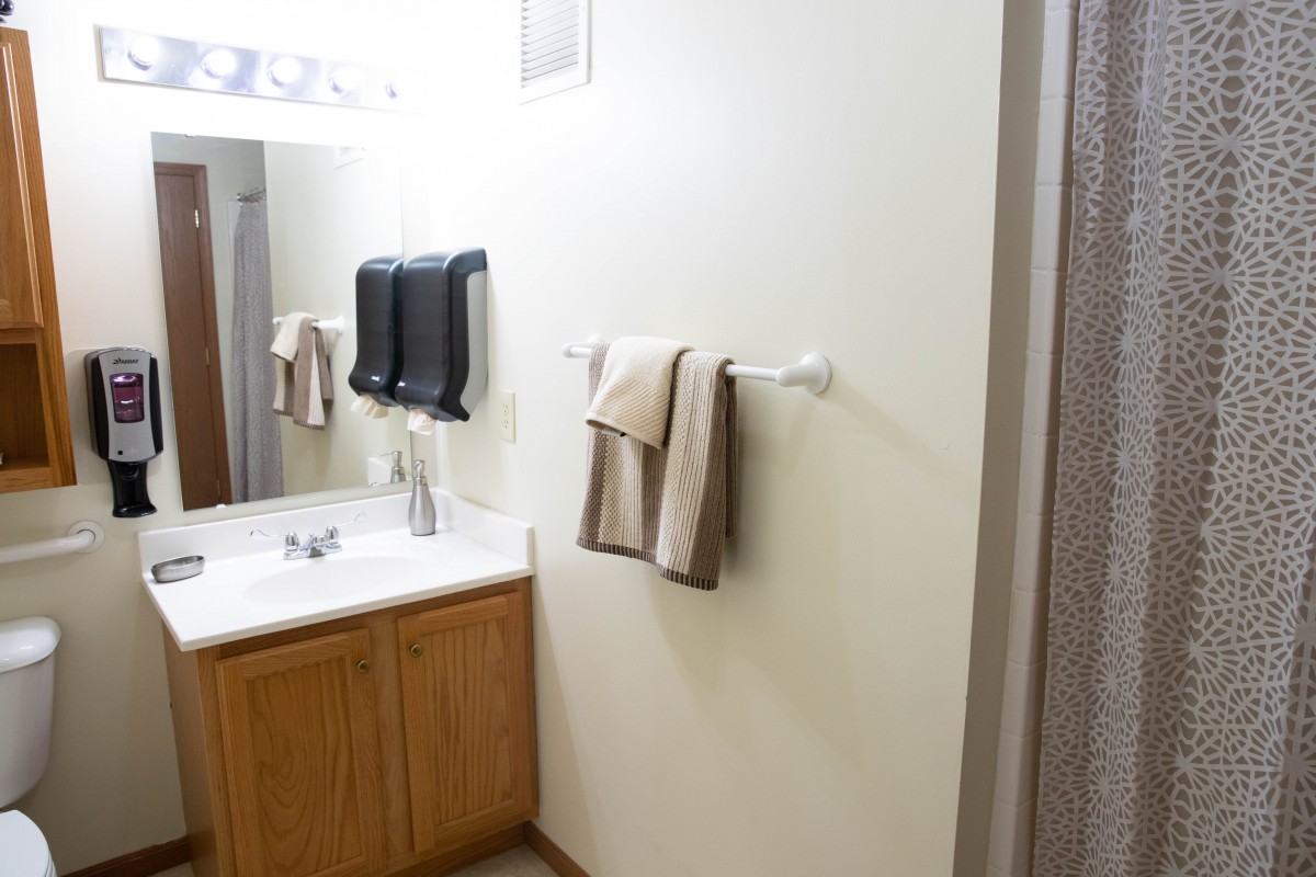 A clean bathroom with a sink, mirror, and towel rack.